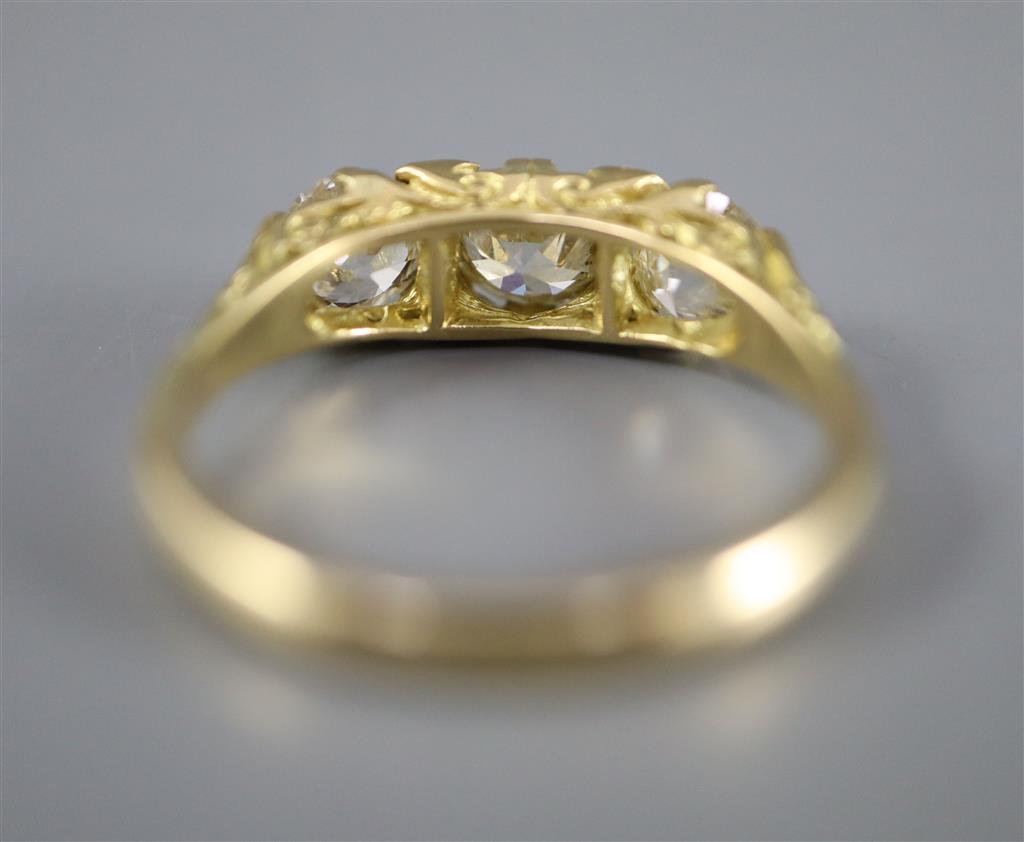 A Victorian style yellow metal and three stone diamond ring with diamond chip spacers, size Q, gross 4.5 grams.
